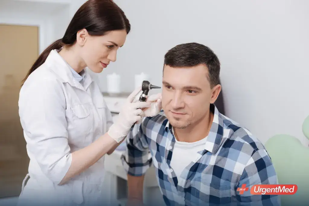 Provider examining a patient's ear with an otoscope