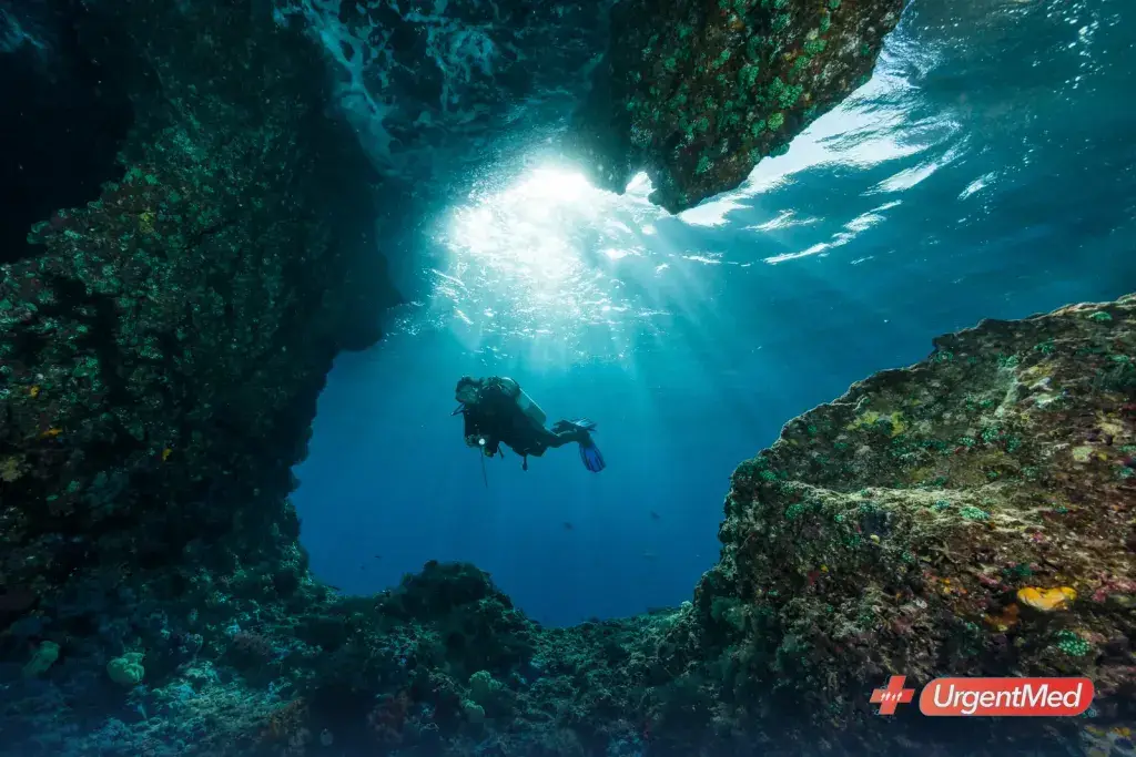 Scuba diver swimming through a reef cavern